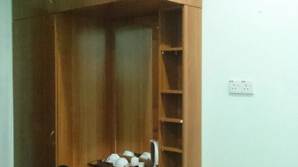 Wardrobe, shelves and tea facilities inside a guest room